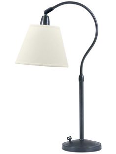 a lamp with a white shade on top of it and a black metal pole underneath