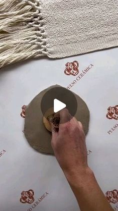 a person is working on a piece of paper that has been rolled up and placed on top of it