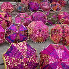 many colorful umbrellas are laying on the ground