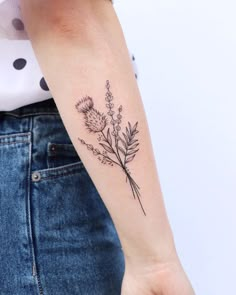 a woman's arm with a flower tattoo on the left side of her arm