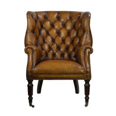 a brown leather chair with wooden legs and an upholstered back, on a white background