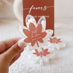 a person holding up a flower shaped card