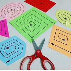 scissors and paper cut out shapes on a table