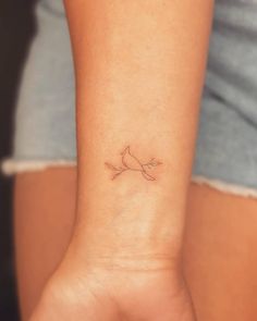 a small bird tattoo on the wrist