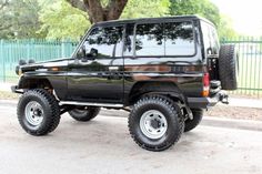 a black jeep parked in front of a tree