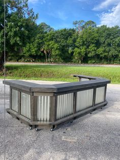 a large rectangular container sitting on top of a parking lot next to a lush green field