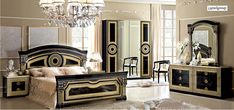 an elegant bedroom with black and gold furniture, chandelier and mirror cabinetry