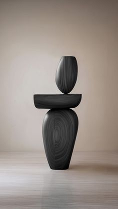 a black chair sitting on top of a wooden floor next to a wall with an abstract design