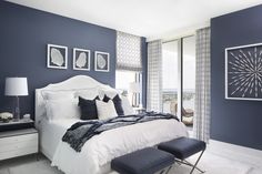 a bedroom with blue walls and white furniture