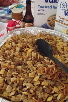 a large metal pan filled with cheetos next to bottles of beer and other snacks