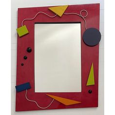 a red frame with various pieces of art on it