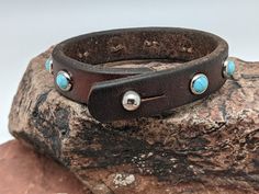 Turquoise (faux) stones are set into this leather bracelet. Wear it as one piece but better yet, layer, layer, layer! The leather is from retired horse tack that has been cleaned, reconditioned and given new life. Note: Leather will vary based upon what is in stock Adjustable Turquoise Leather Bracelet In Rustic Style, Adjustable Rustic Turquoise Leather Bracelet, Turquoise Leather Concho Bracelets, Western Style Turquoise Leather Bracelets, Adjustable Western Leather Bracelet, Adjustable Turquoise Western Bracelet, Rustic Turquoise Leather Bracelet, Adjustable Turquoise Leather Bracelet With Concho, Adjustable Turquoise Leather Bracelet Southwestern Style