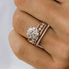 a woman's hand with two rings on it and a diamond in the middle