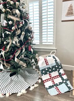 a christmas tree is decorated with ribbon and ornaments, along with a quilted pot holder