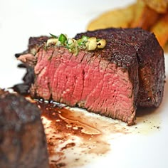 a piece of steak on a plate with potatoes