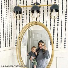 a woman taking a selfie in front of a mirror with a baby on her lap