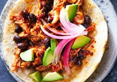 a tortilla with black beans, onions and avocado