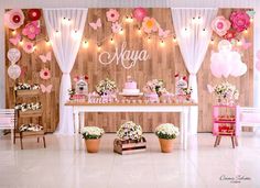 a table with flowers and cake on it in front of a wooden wall that says mayoa