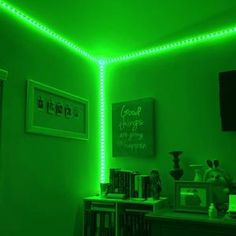 a room with green lights on the wall and bookshelves in front of it