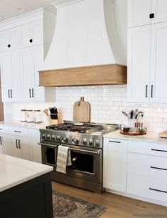 a stove top oven sitting inside of a kitchen next to white cabinets and counter tops