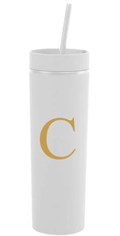 a white tumbler with a gold c on the side and a straw in it