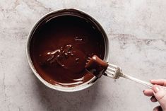 someone is stirring chocolate into a saucepan