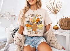 Get ready to show your gratitude this Thanksgiving with our "One Thankful Teacher" t-shirt! Whether you're celebrating the holiday with your little learners or simply spreading a message of thankfulness, this shirt is a must-have for any teacher. DETAILS * Bella + Canvas Unisex Premium T-Shirt  * Soft and lightweight  * 100% combed and ring-spun cotton  * Heather colors are 52% combed and ring-spun cotton, 48% polyester * Design is printed using DTG technology which uses high-quality water-based inks that are printed directly into the fabric.  This means that there may be a slightly faded/vintage look to the design depending on the color and fabric of the garment. SIZING * These unisex T-shirts are true-to-size. * Most women find their typical size works best since they are meant to be a b Cute Thanksgiving Teacher Shirts, Fall Teacher Shirts, Teacher Thanksgiving, Teachers Thanksgiving, Teacher Tees, Trendy Tee, Teacher Tshirts, Appreciation Gifts, Cozy Sweatshirts