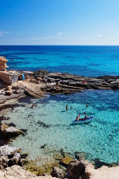 people are swimming in the clear blue water