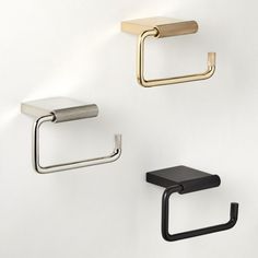 three different types of wall mounted toilet paper holders on a white wall with black and gold handles