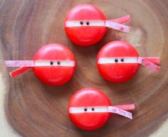 three red apples with faces taped to them