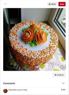 there is a cake with orange flowers on the table next to a window sill