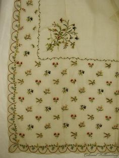 an embroidered table cloth with flowers on it