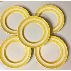 four yellow and white plates stacked on top of each other in the shape of circles