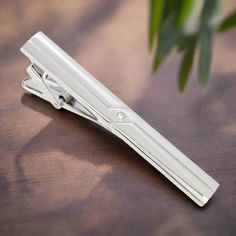 This chrome tie clip, adorned with intricate designs, adds a subtle yet sophisticated flair to any outfit. Its polished finish and detailed craftsmanship make it versatile and eye-catching. Dress Shirts: Solid Light Blue Dress Shirt - Provides a gentle contrast that highlights the intricate chrome details. White Dress Shirt with Fine Stripes - Adds a textured look while maintaining a classic style. Soft Pink Dress Shirt - Offers a stylish and modern touch that pairs well with the chrome finish. Luxury Silver Suit And Tie Accessories For Business, Elegant Silver Suit And Tie Accessories For Gift, Silver Elegant Suit And Tie Accessories For Gift, Modern Silver Suit And Tie Accessories For Business, Silver Suit And Tie Accessories For Formal Occasions, Elegant Silver Suit And Tie Accessories For Formal Events, Classic Silver Lapel Pin For Business, Luxury Silver Suit And Tie Accessories For Formal Occasions, Soft Pink Dress