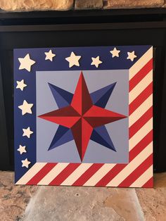 a red, white and blue star with stars on it in front of a fireplace