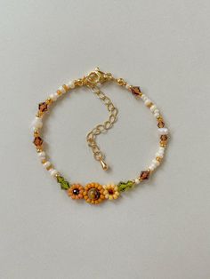 Bracelet Length: 6-8 inches  Each Bracelet has a 2 inch 14k gold filled extender This bracelet features different shades of hand woven yellow sunflowers and fall colors of cream, brown, green, and gold.  This dainty piece is made up of high quality seed beads including 24kt gold plated beads, crystals, and tigers eye. Strung on: Non-Stretchy Beading Thread Sunflower Thread Bracelet, How To Make A Sunflower Bracelet, Fall Beads Bracelet, Cheap Yellow Flower Bracelet, Beaded Sunflower Bracelet, Daisy Seed Bead Bracelet, Sunflower Friendship Bracelet Pattern, Yellow Bracelet Ideas, Yellow Beaded Bracelets