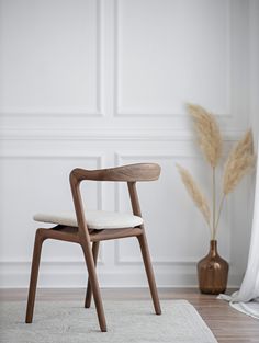 a wooden chair sitting on top of a white rug