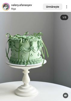 a green cake sitting on top of a white table