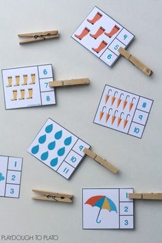 several match cards with clothes pins and umbrellas on them are arranged in the shape of numbers