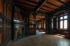 an empty room with wood paneling and large windows