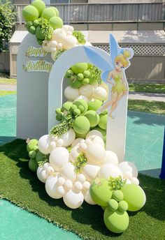 the balloon arch is decorated with green and white balloons