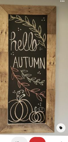 a chalkboard with autumn written on it in a wooden frame hanging on the wall