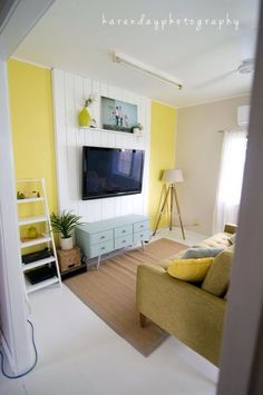 a living room filled with furniture and a flat screen tv mounted on a wall above it