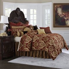 a bed with red and gold comforters in a bedroom