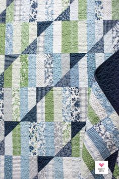 a blue and green quilt on top of a black table cloth with the words, patchwork