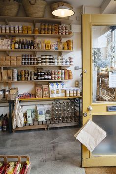 a store filled with lots of different types of food on shelves next to a yellow door