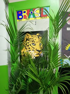 there is a green plant in front of a wall with an image of a leopard on it