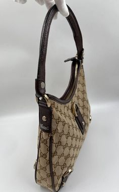 A stunning vintage Gucci trapeze shoulder bag made from the iconic GG beige canvas with brown leather trim and Gucci branded pale gold hardware. Inside the bag is lined with brown cotton lining and there is a zipped pocket for valuables. This bag is in good vintage condition with some slight wear to the leather parts. Made in Italy. Height: 24cm Width: 30cm Depth: 5cm To ensure you’re completely satisfied with your purchase, please refer to the images for the exact condition of the item. Gucci Brand, Gucci Shoulder Bag, Pale Gold, Bags Designer Fashion, Exclusive Bag, New Bag, Leather Trim, Vintage Gucci, Exclusive Designs