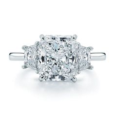 a three stone diamond ring with two princess cut diamonds on the sides and side stones