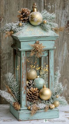 an old blue lantern with pine cones and ornaments